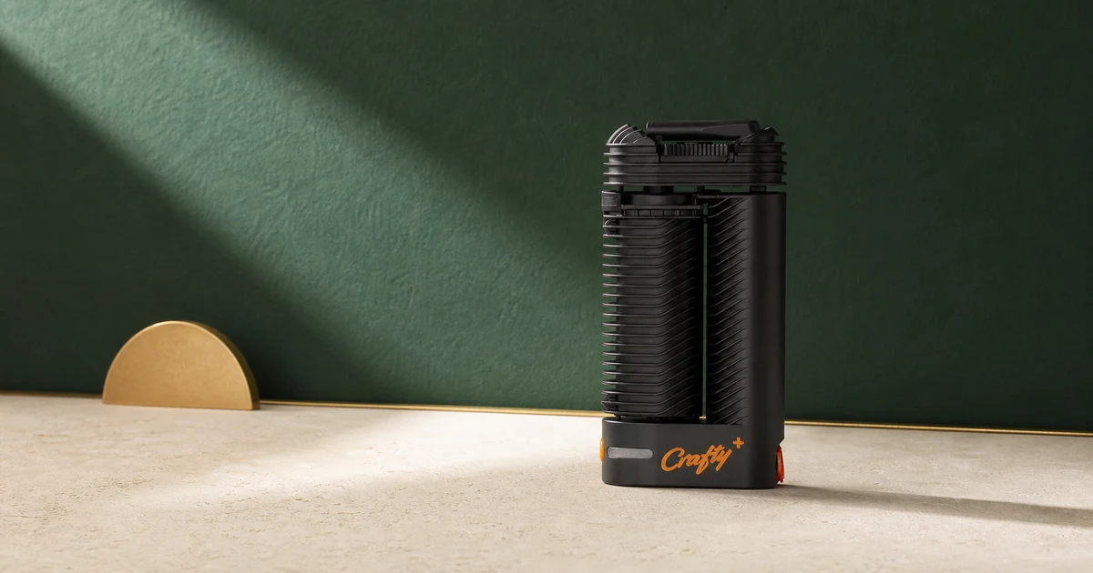 A Storz & Bickel Crafty+ vaporiser photographed against a deep green editorial backdrop.