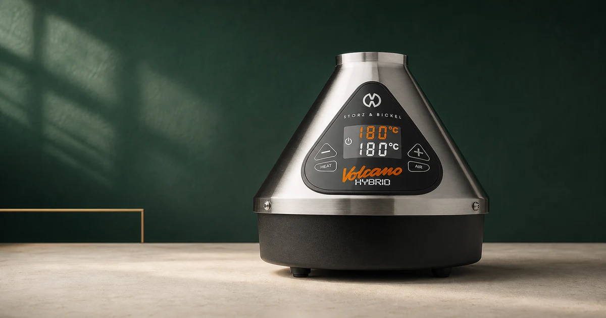 A Storz & Bickel Volcano Hybrid desktop vaporiser photographed against a deep green editorial backdrop.
